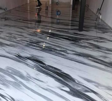 Detalle de suelo epoxi autonivelante gris brillante en garaje