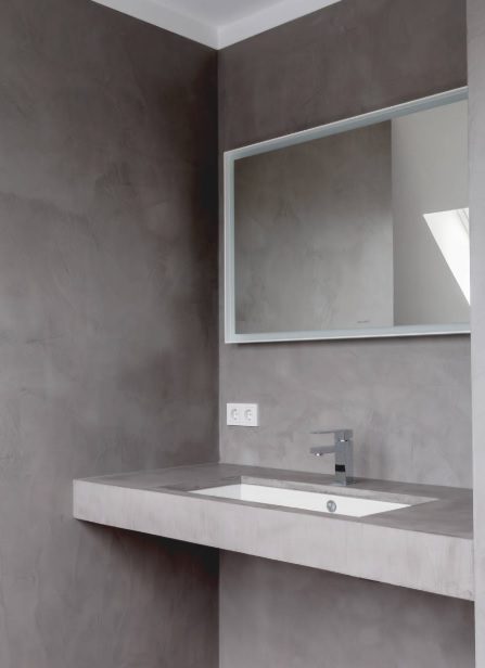 Baño con paredes y suelo de microcemento gris claro sin juntas